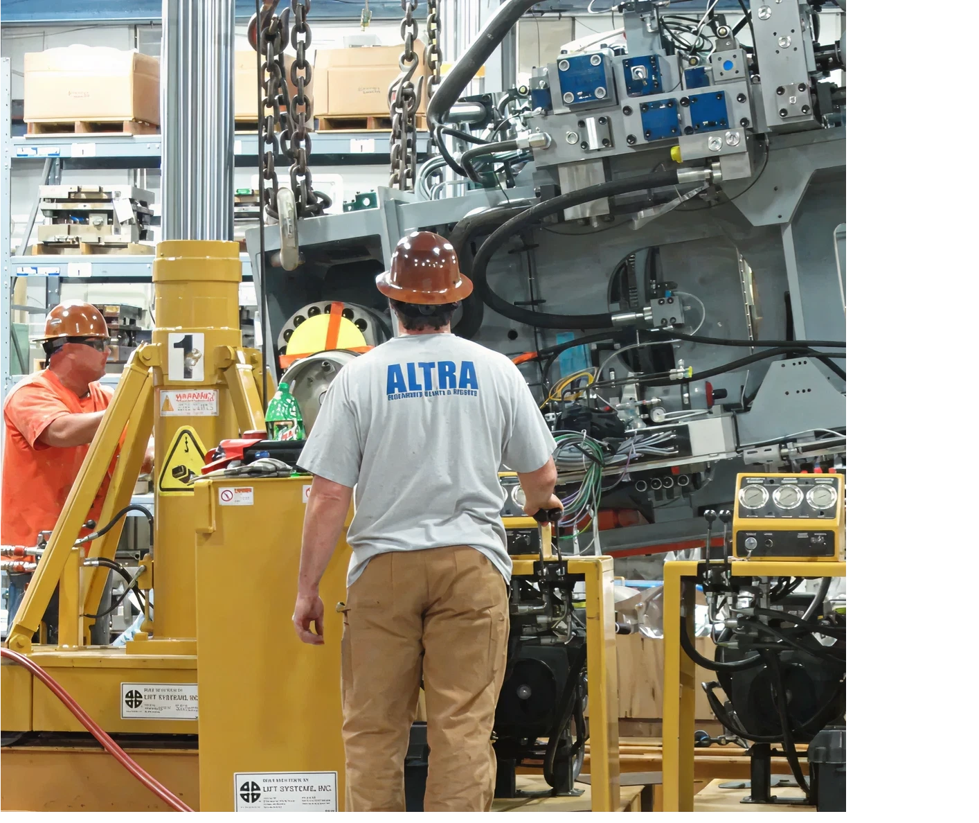 Workers operating heavy machinery in factory